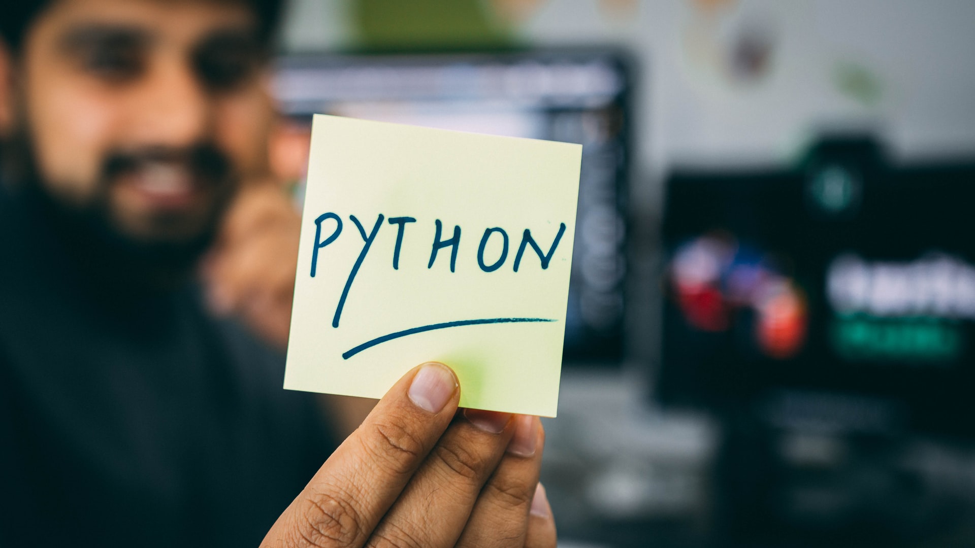 Pessoa segundando postit escrito Python